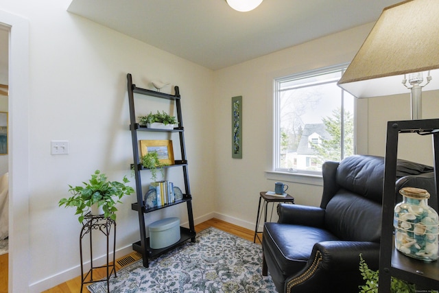 sitting room with baseboards and light wood finished floors