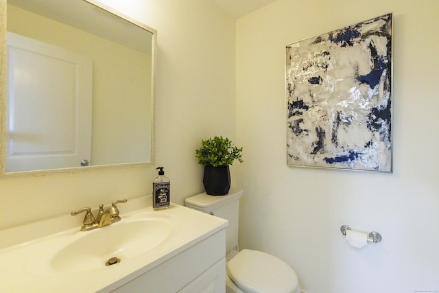 half bathroom with vanity and toilet