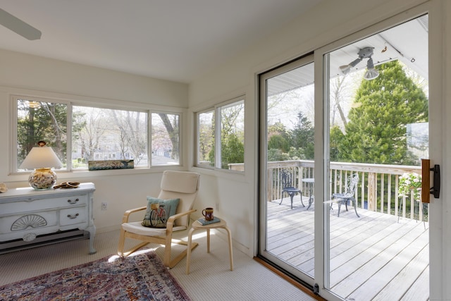 sunroom featuring a deck, baseboards, and plenty of natural light