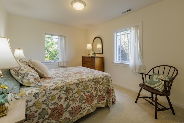 carpeted bedroom with visible vents and baseboards