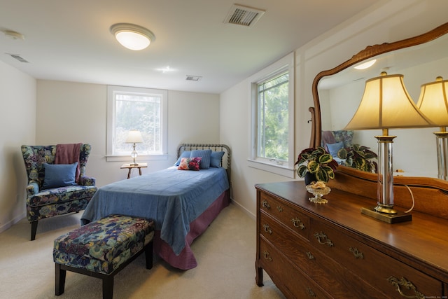 bedroom featuring visible vents and light colored carpet