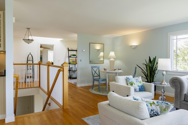living room featuring wood finished floors, ceiling fan, and baseboards
