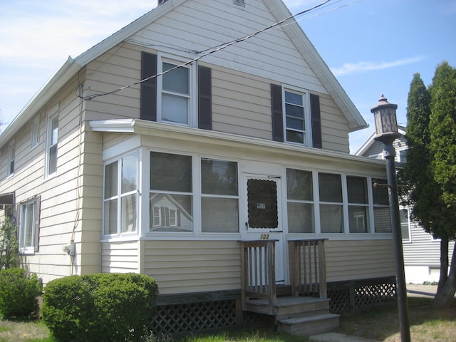rear view of house featuring a sunroom