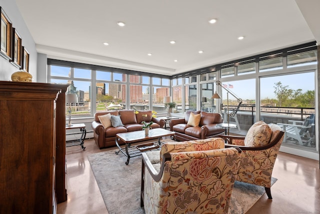 sunroom with concrete floors, a view of city, a baseboard radiator, and recessed lighting