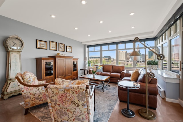 living area with concrete floors, a view of city, baseboard heating, and recessed lighting