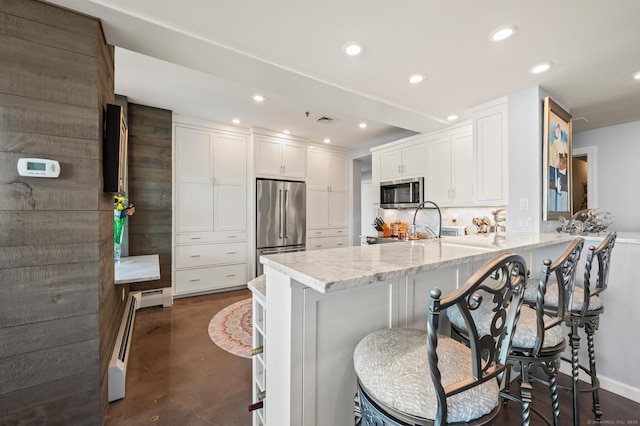 kitchen with a peninsula, white cabinetry, stainless steel appliances, and recessed lighting