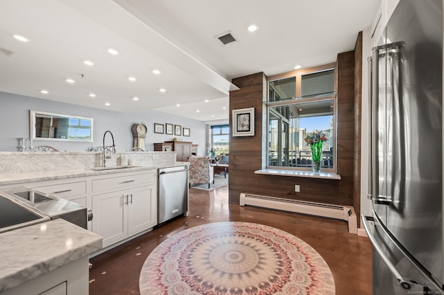 kitchen with a sink, stainless steel appliances, white cabinets, visible vents, and baseboard heating