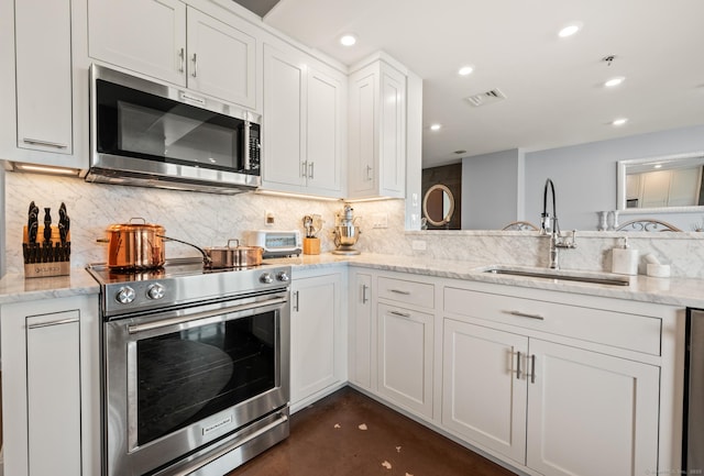 kitchen featuring tasteful backsplash, visible vents, a sink, white cabinets, and appliances with stainless steel finishes