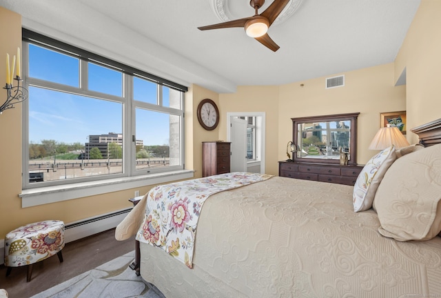 carpeted bedroom with ceiling fan, a baseboard radiator, and visible vents