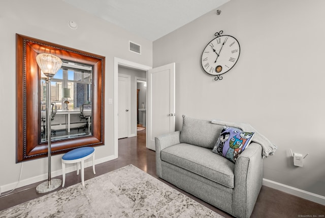 living area featuring baseboards and visible vents