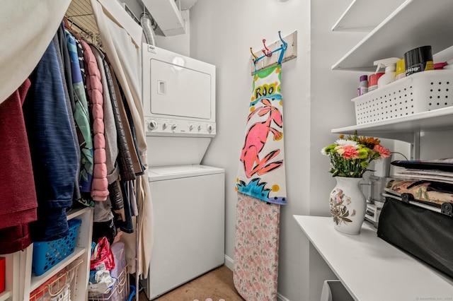 washroom featuring stacked washer / dryer and laundry area