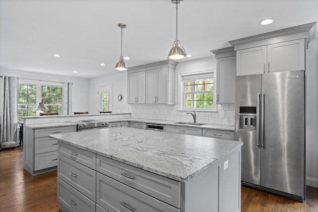 kitchen featuring appliances with stainless steel finishes, gray cabinetry, a sink, a peninsula, and recessed lighting