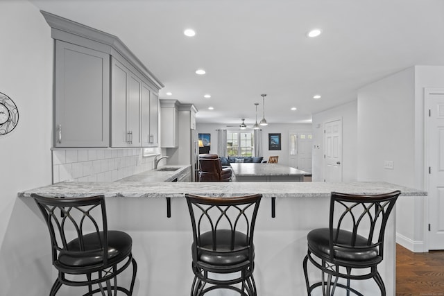 kitchen featuring gray cabinets, recessed lighting, dark wood-style flooring, a peninsula, and tasteful backsplash