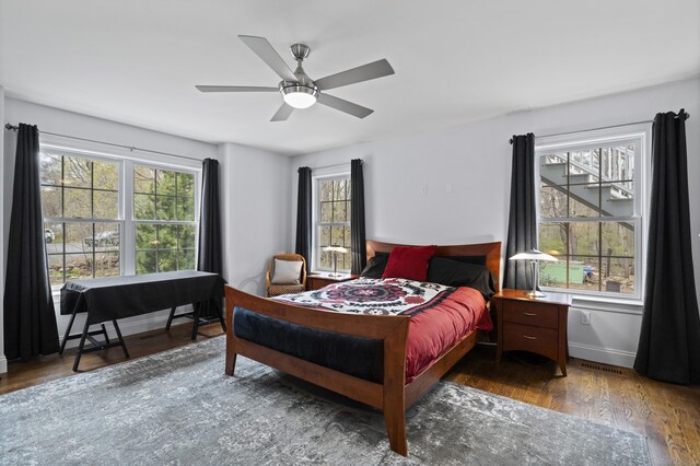 bedroom featuring wood finished floors, baseboards, and a ceiling fan