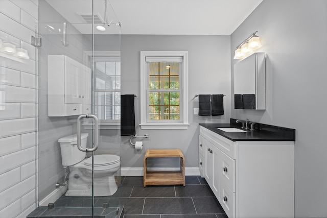 bathroom with tile patterned flooring, toilet, a shower stall, and vanity