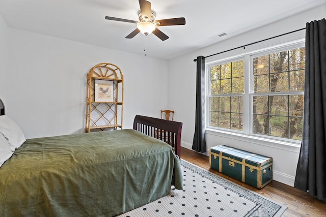 bedroom featuring wood finished floors, baseboards, and ceiling fan