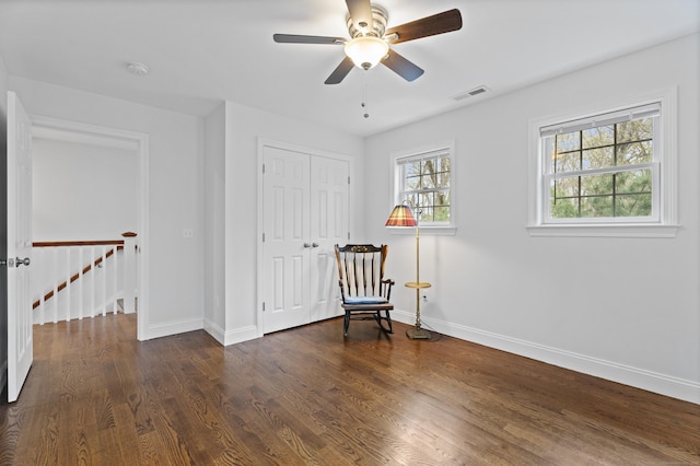 living area with baseboards, wood finished floors, an upstairs landing, and a ceiling fan