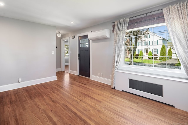 43 Bibbins Ave, Fairfield, CT 06825 - foyer entrance with baseboards, a wall unit AC, a wealth of natural light, and wood finished floors