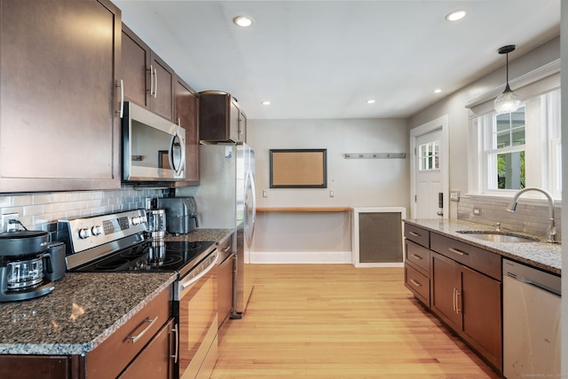 43 Bibbins Ave, Fairfield, CT 06825 - kitchen featuring appliances with stainless steel finishes, a sink, light wood-style flooring, baseboards, and backsplash