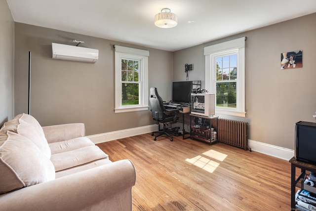 43 Bibbins Ave, Fairfield, CT 06825 - office area featuring a wall unit AC, wood finished floors, radiator, and a wealth of natural light