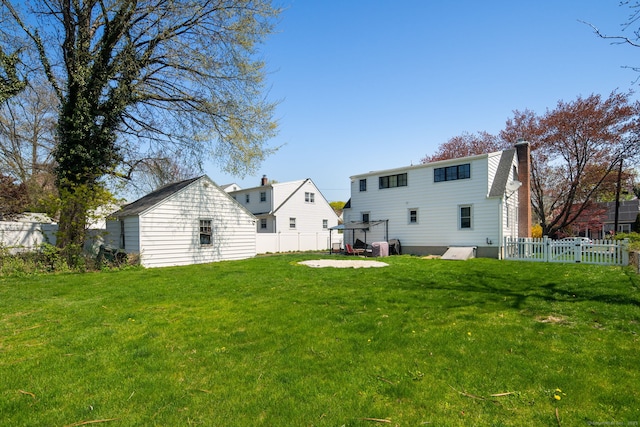 43 Bibbins Ave, Fairfield, CT 06825 - rear view of house featuring a fenced backyard, a chimney, and a lawn