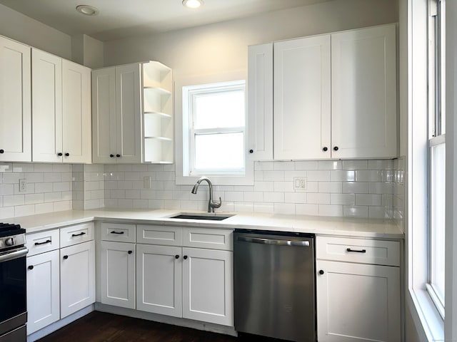 65 Beach St, Bridgeport, CT 06608 - kitchen featuring white cabinets, light countertops, stainless steel dishwasher, a sink, and range with gas stovetop