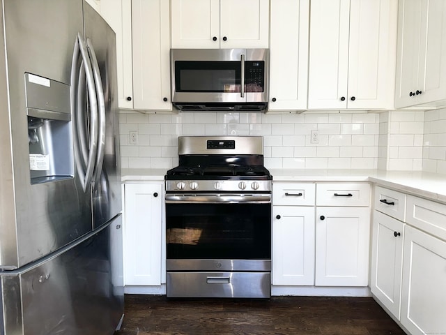65 Beach St, Bridgeport, CT 06608 - kitchen with white cabinets, stainless steel appliances, tasteful backsplash, light countertops, and dark wood-type flooring