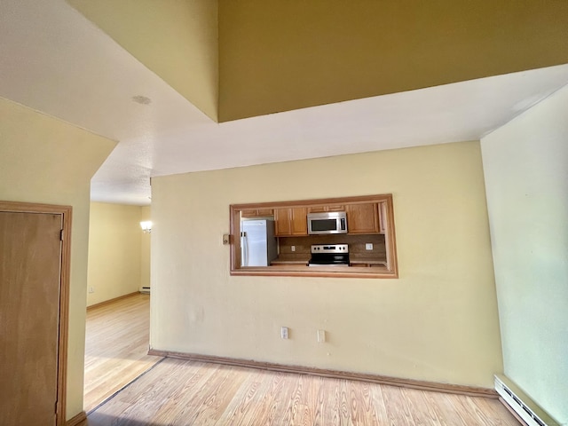 6 Stirling Ct, Middletown, CT 06457 - unfurnished living room featuring a baseboard heating unit, baseboards, and light wood-style floors