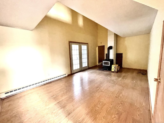 6 Stirling Ct, Middletown, CT 06457 - unfurnished living room featuring wood finished floors, a wood stove, a baseboard radiator, french doors, and high vaulted ceiling