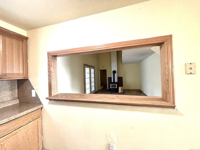 6 Stirling Ct, Middletown, CT 06457 - interior space featuring a wood stove, black microwave, decorative backsplash, and light brown cabinets