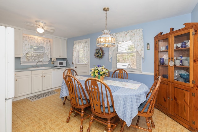 dining room featuring light floors and ceiling fan with notable chandelier