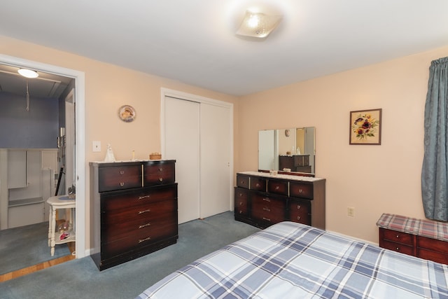 bedroom with a closet, attic access, and dark colored carpet