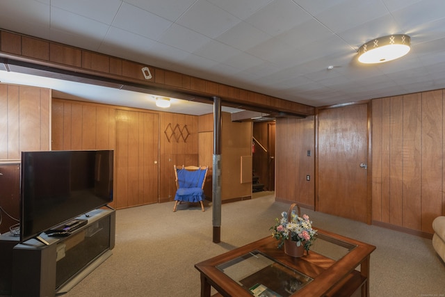 living area featuring wooden walls, carpet flooring, and stairs
