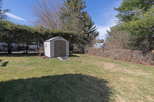 view of yard with fence, an outdoor structure, and a storage unit