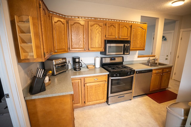 30 Merrimac St, Watertown, CT 06779 - kitchen featuring brown cabinetry, stainless steel appliances, a toaster, light countertops, and a sink