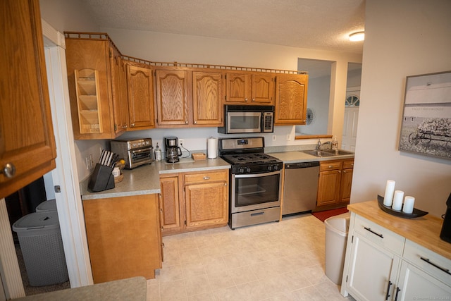 30 Merrimac St, Watertown, CT 06779 - kitchen featuring appliances with stainless steel finishes, brown cabinets, light countertops, and a sink