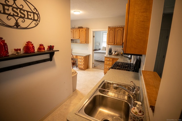 30 Merrimac St, Watertown, CT 06779 - kitchen featuring light countertops, brown cabinets, range with gas stovetop, and a sink