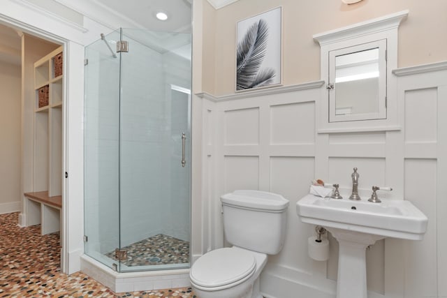 190 Hillspoint Rd, Westport, CT 06880 - full bathroom with a decorative wall, toilet, a wainscoted wall, a sink, and a stall shower