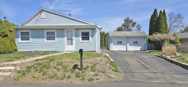 view of front of property featuring fence, an outdoor structure, and a detached garage
