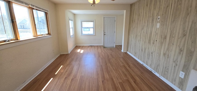 doorway with baseboards, wood finished floors, and ceiling fan