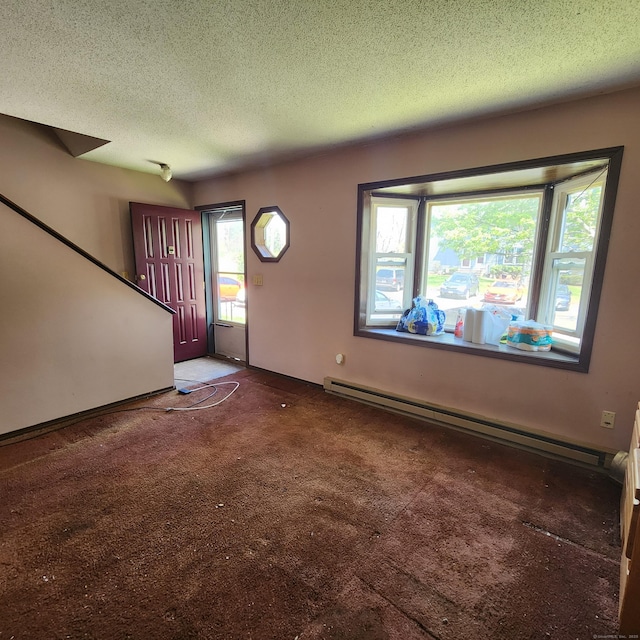 carpeted foyer featuring a wealth of natural light, a baseboard heating unit, and a textured ceiling
