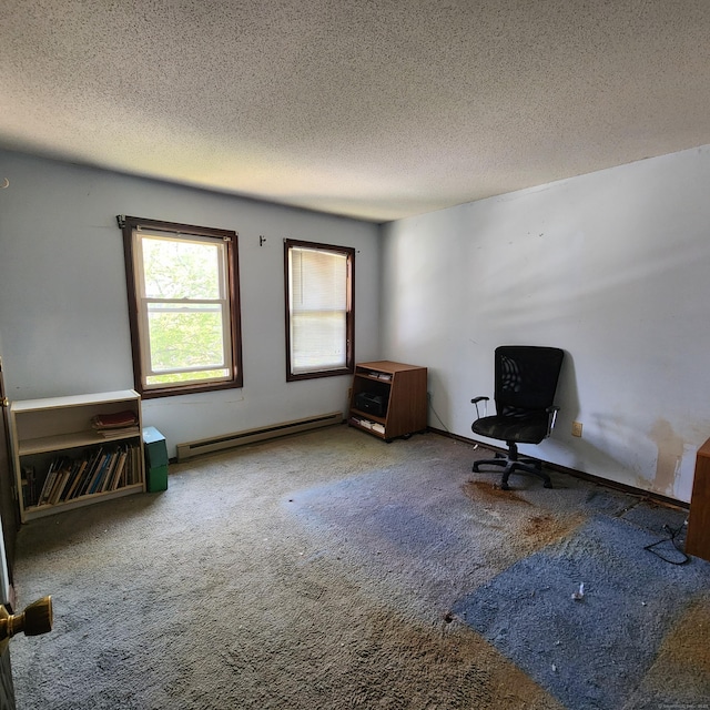 unfurnished room with a baseboard heating unit, a textured ceiling, and carpet
