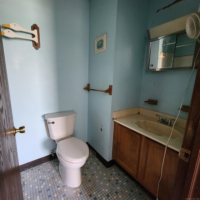 bathroom with toilet, tile patterned flooring, vanity, and baseboards