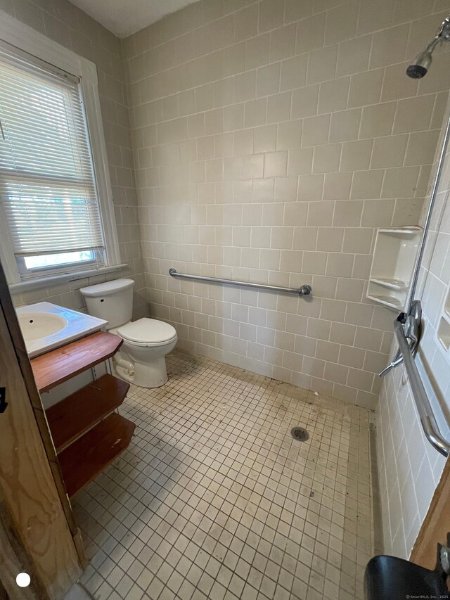 408 Blohm St, West Haven, CT 06516 - full bathroom featuring tile walls, vanity, tile patterned floors, toilet, and tiled shower
