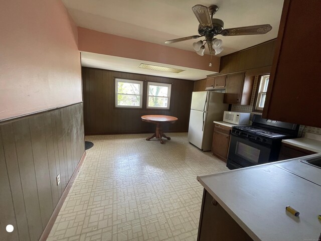 408 Blohm St, West Haven, CT 06516 - kitchen featuring wooden walls, light countertops, a ceiling fan, and white appliances