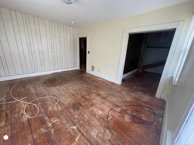 408 Blohm St, West Haven, CT 06516 - spare room featuring baseboards, wood walls, hardwood / wood-style floors, and visible vents