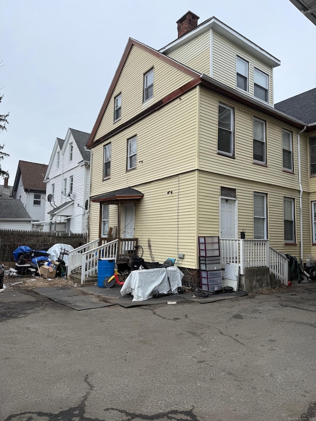view of front of home with fence and a chimney