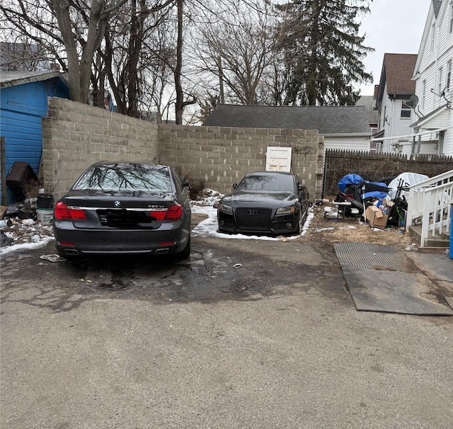 uncovered parking lot featuring fence