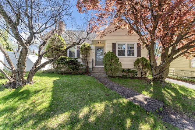 view of front of property featuring a front lawn and fence