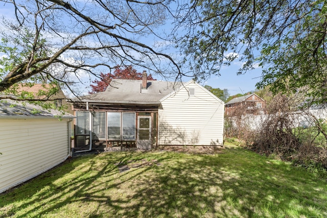 rear view of house with a lawn and a chimney
